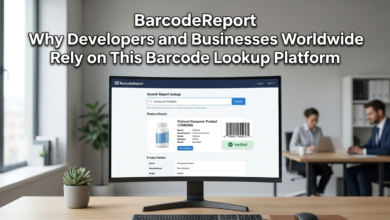 A computer monitor displaying a BarcodeReport lookup on a wooden desk, with people in a modern office.